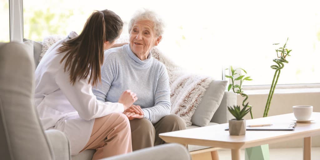 dystrofia miotoniczna - zdjęcie przedstawia pracownika medycznego rozmawiającego ze starszym pacjentem