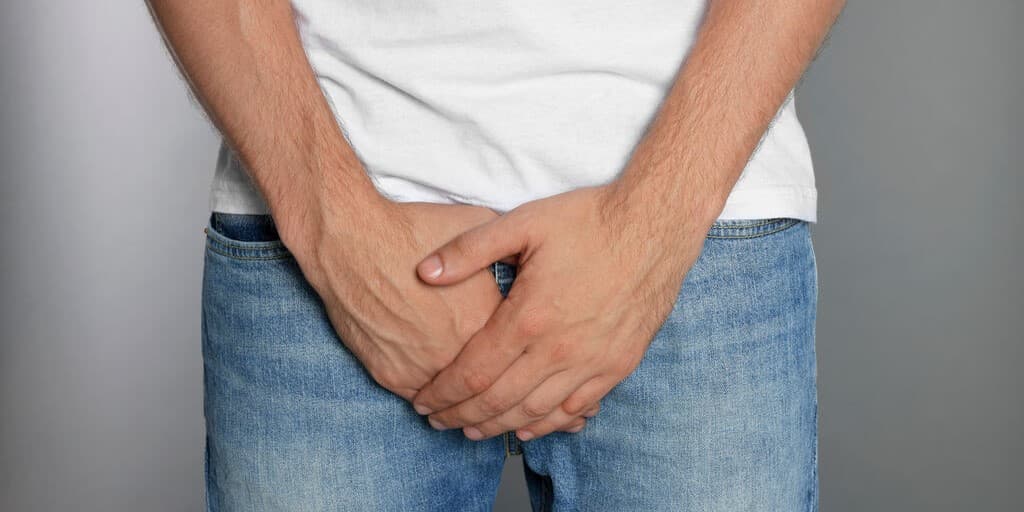 Skręt jądra u mężczyzny, który trzyma się za krocze