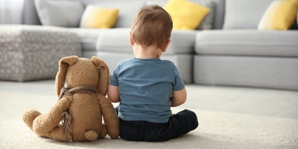 Zespół Noonan - zdjęcie przedstawia dziecko siedzące obok pluszaka